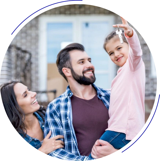 A man and woman smile while a child holds up a set of keys. They are standing in front of a house.